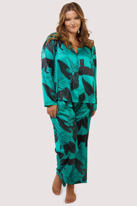 Green satin pyjamas with a pocket on the breast, in a black panther and leaf print design.