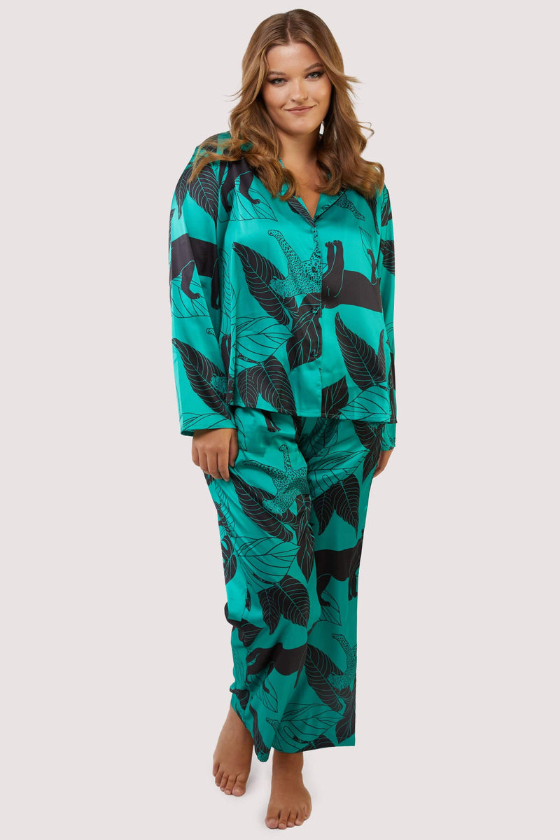 Green satin pyjamas with a pocket on the breast, in a black panther and leaf print design.