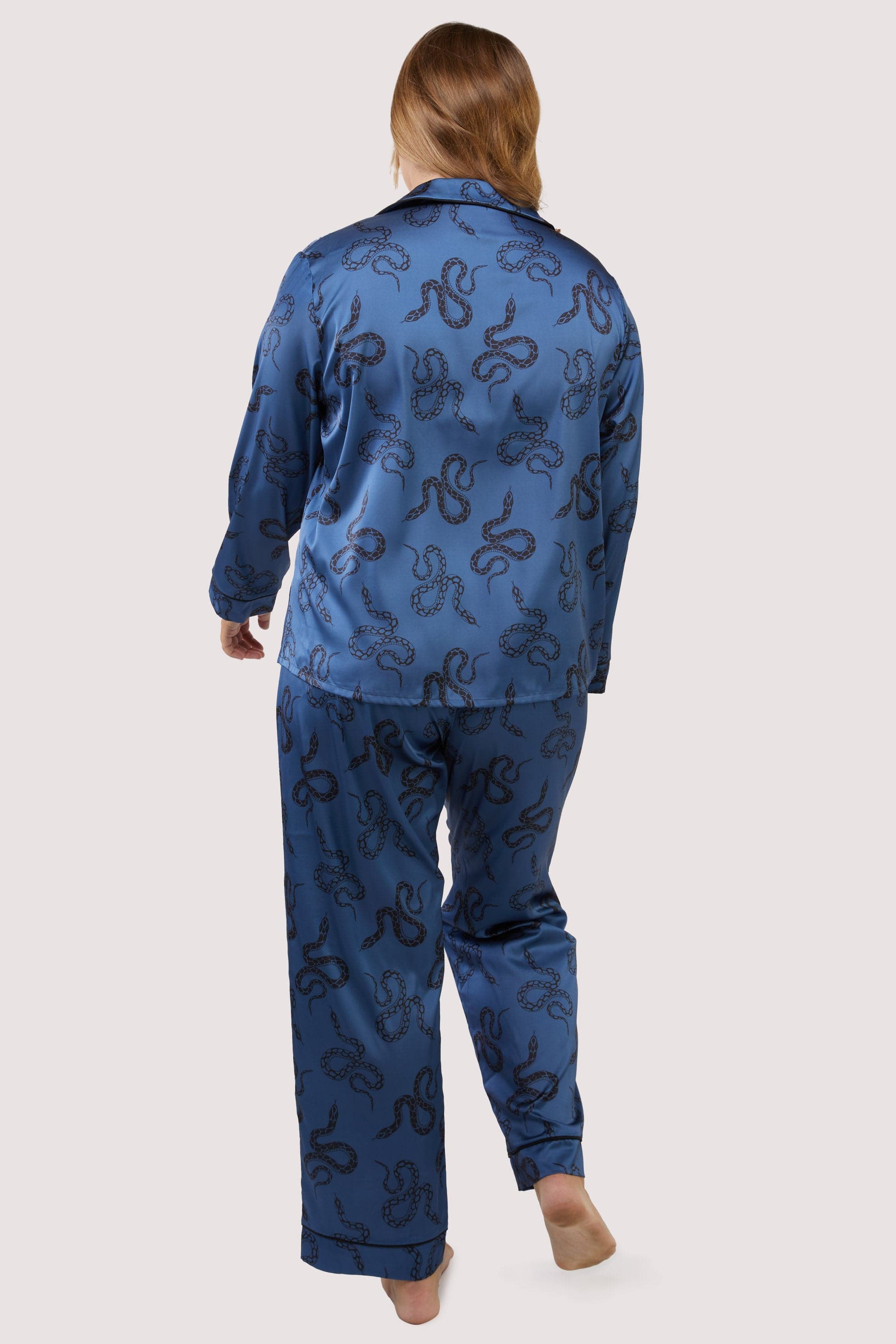 Back view of blue satin pyjamas with a pocket on the breast, in a black snake print design.