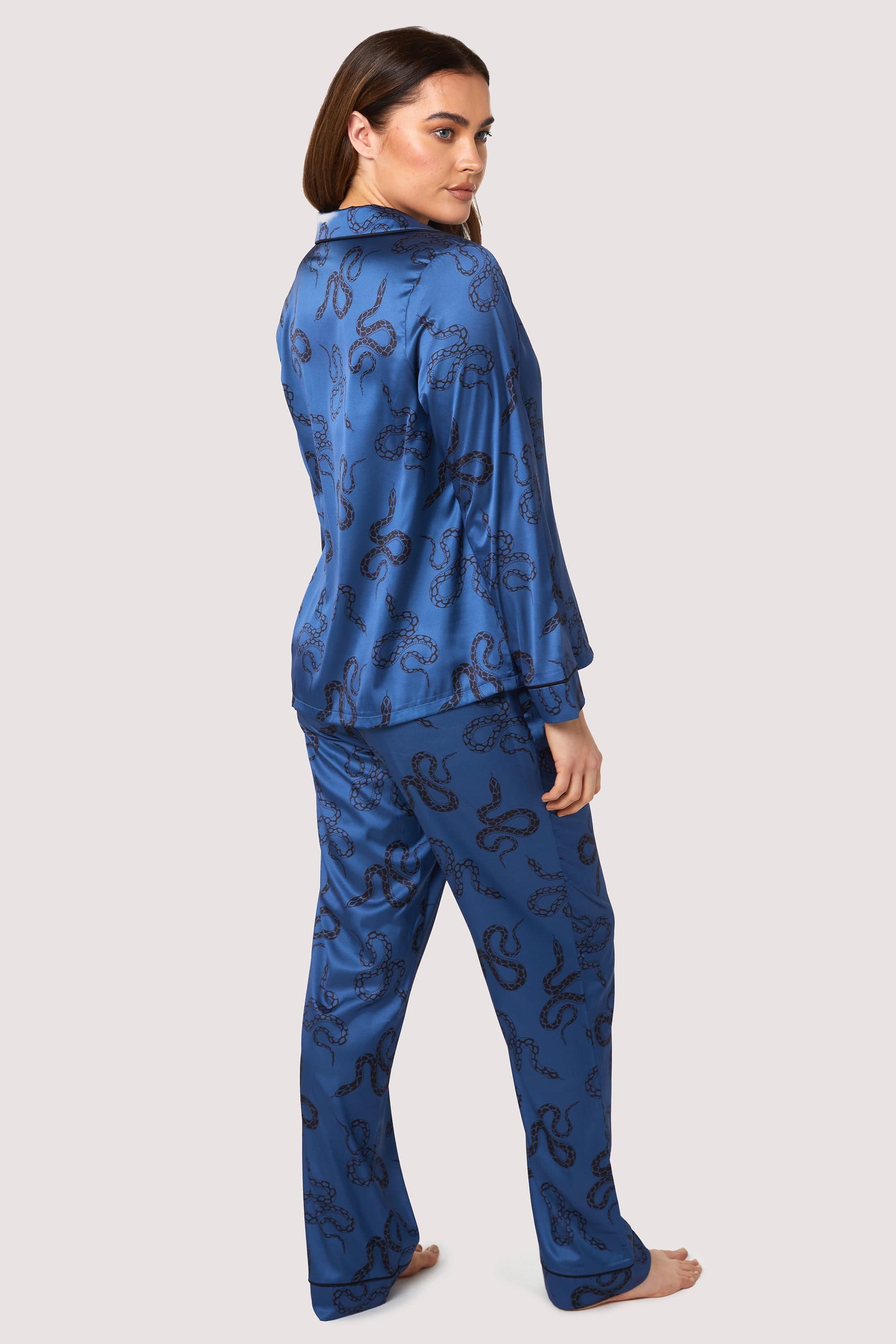 Blue satin pyjamas with a pocket on the breast, in a black snake print design.