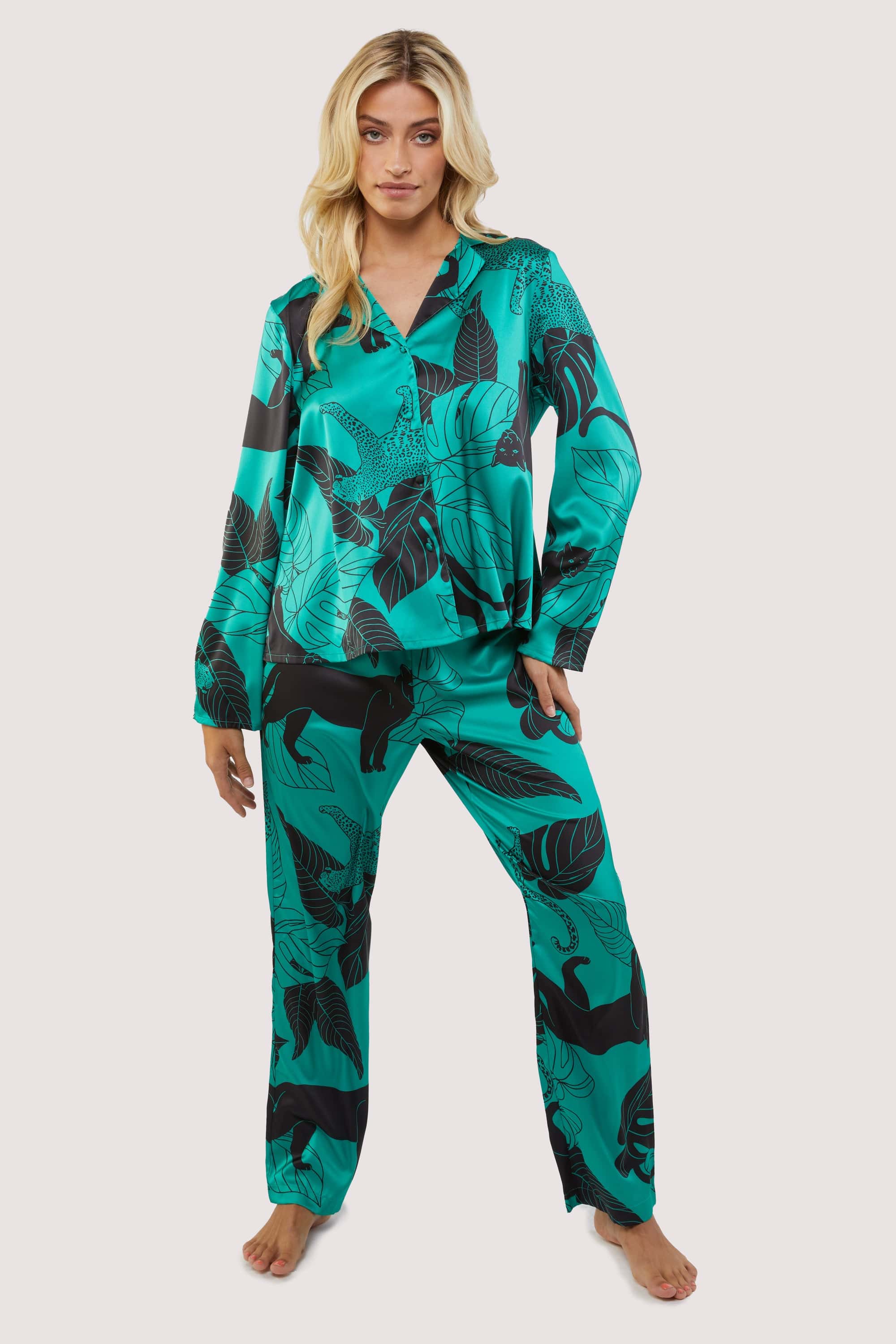 Green satin pyjamas with a pocket on the breast, in a black panther and leaf print design.